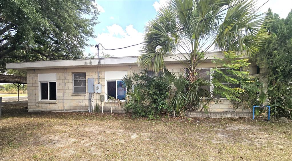 The exterior of a single-story concrete block house features a flat roof and palm trees — 620 S COLLINS STREET, PLANT CITY, FL