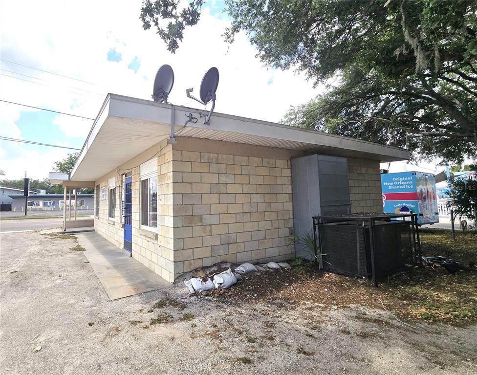 A single-story commercial building with concrete block walls, a flat roof, and satellite dishes — 620 S COLLINS STREET, PLANT CITY, FL