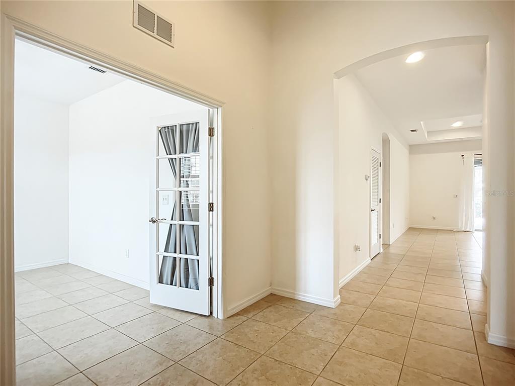 A tiled entryway leads to a room with French doors and a long hallway — 5384 LAYTON DRIVE, VENICE, FL