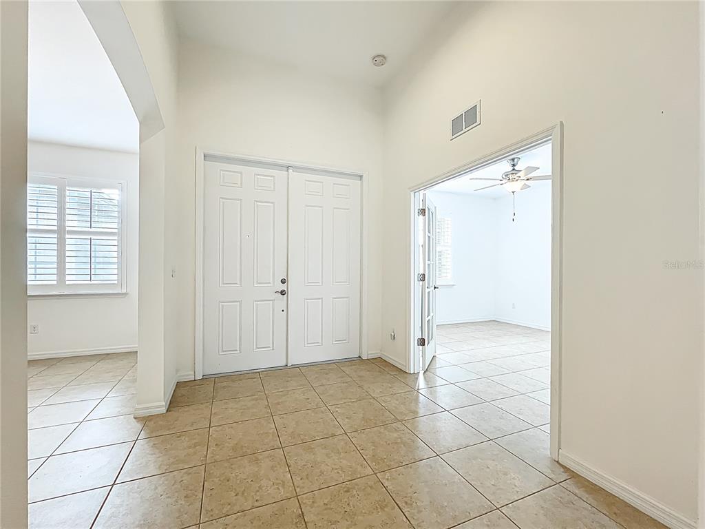 A tiled entryway features double front doors and an open doorway leading to a room — 5384 LAYTON DRIVE, VENICE, FL