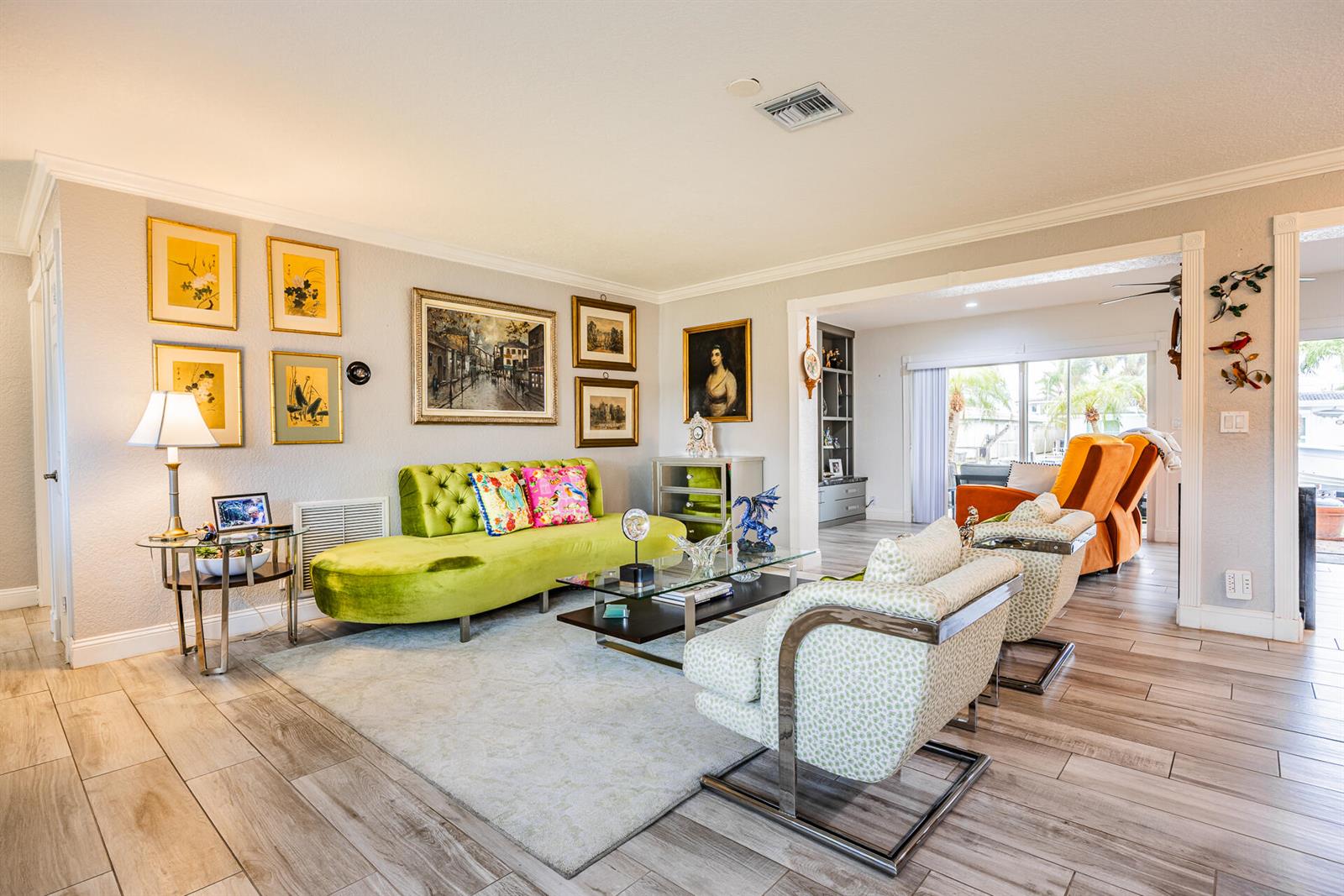 A living room features a lime green sofa, two patterned armchairs, and light wood flooring — 801 SE 5th Terrace, Pompano Beach FL 33060, POMPANO BEACH, FL