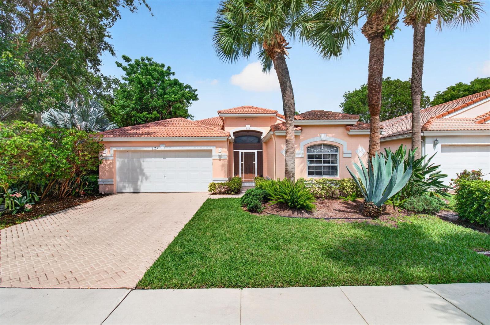 A single-story peach-colored house with a tile roof, two-car garage, and palm trees — 6265 Coral Reef Terrace, Boynton Beach FL 33437, BOYNTON BEACH, FL