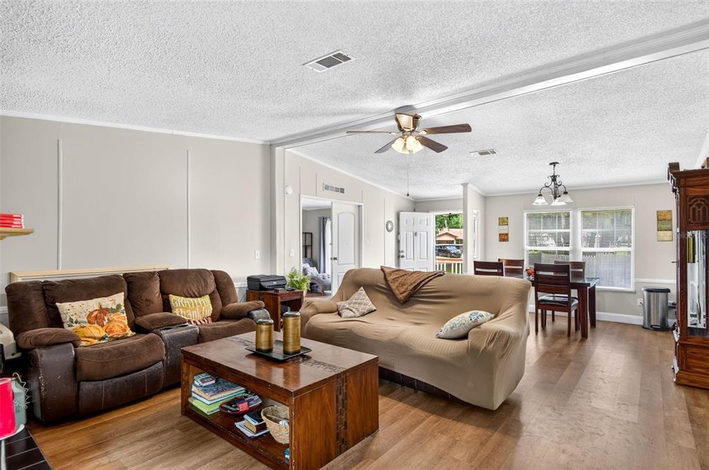 A living room features a brown sofa, a tan slipcovered sofa, and a wooden coffee table — 12641 IDLEWOOD DRIVE, THONOTOSASSA, FL