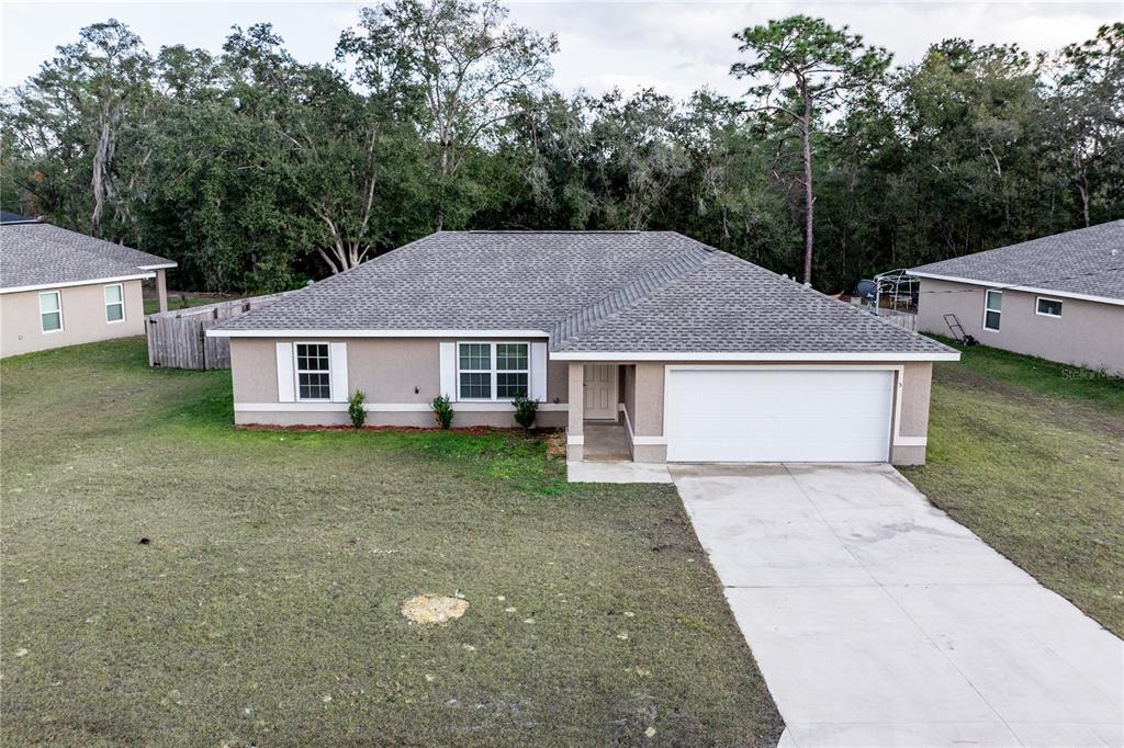 An aerial view of a single-story suburban house with a gray roof and white garage — 5 MALAUKA RADIAL CIRCLE, OCKLAWAHA, FL
