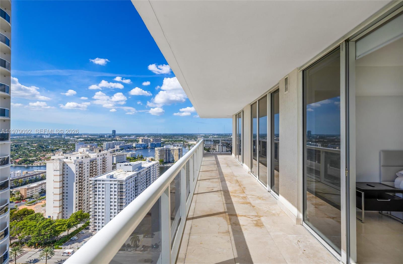 A high-rise balcony features tile flooring, glass railings, and expansive views of the city — 1830 S Ocean Dr # 2806, Hallandale Beach FL 33009, HALLANDALE BEACH, FL