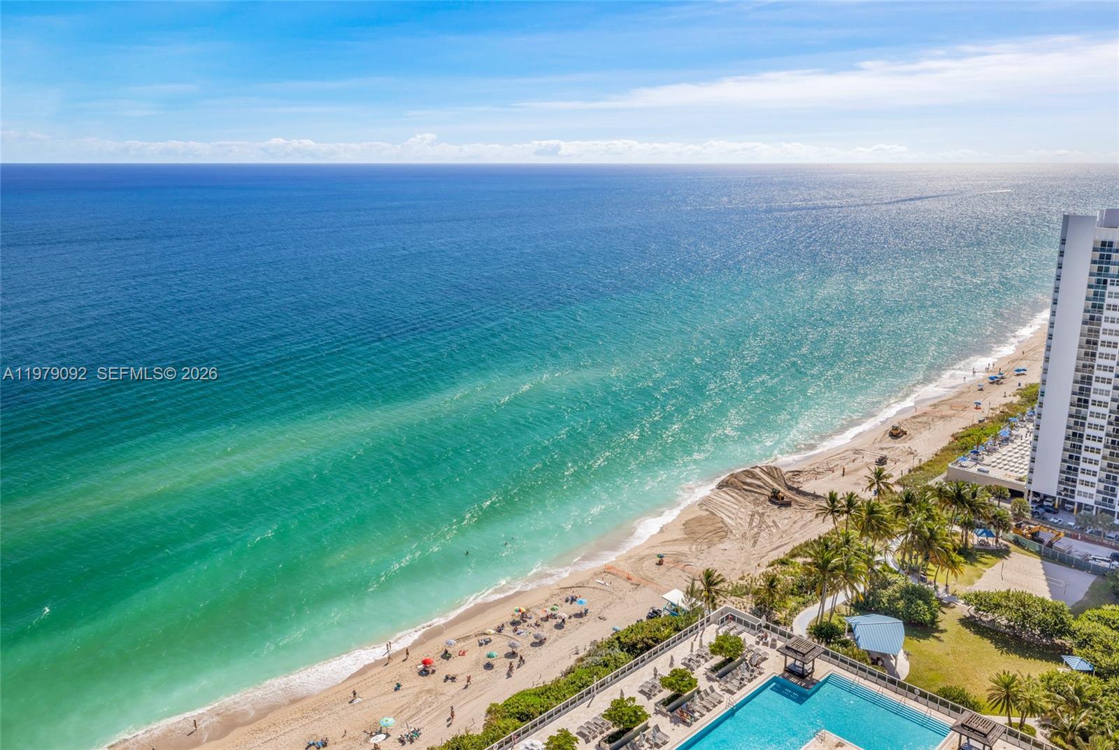 An aerial view shows a sandy beach, turquoise ocean, and a swimming pool deck — 1830 S Ocean Dr # 2806, Hallandale Beach FL 33009, HALLANDALE BEACH, FL