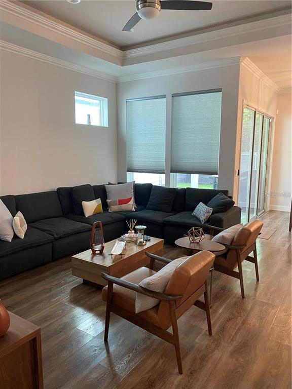 A living room features a large dark sectional sofa, two leather chairs, and wood flooring — 6487 SW 74TH DRIVE, GAINESVILLE, FL