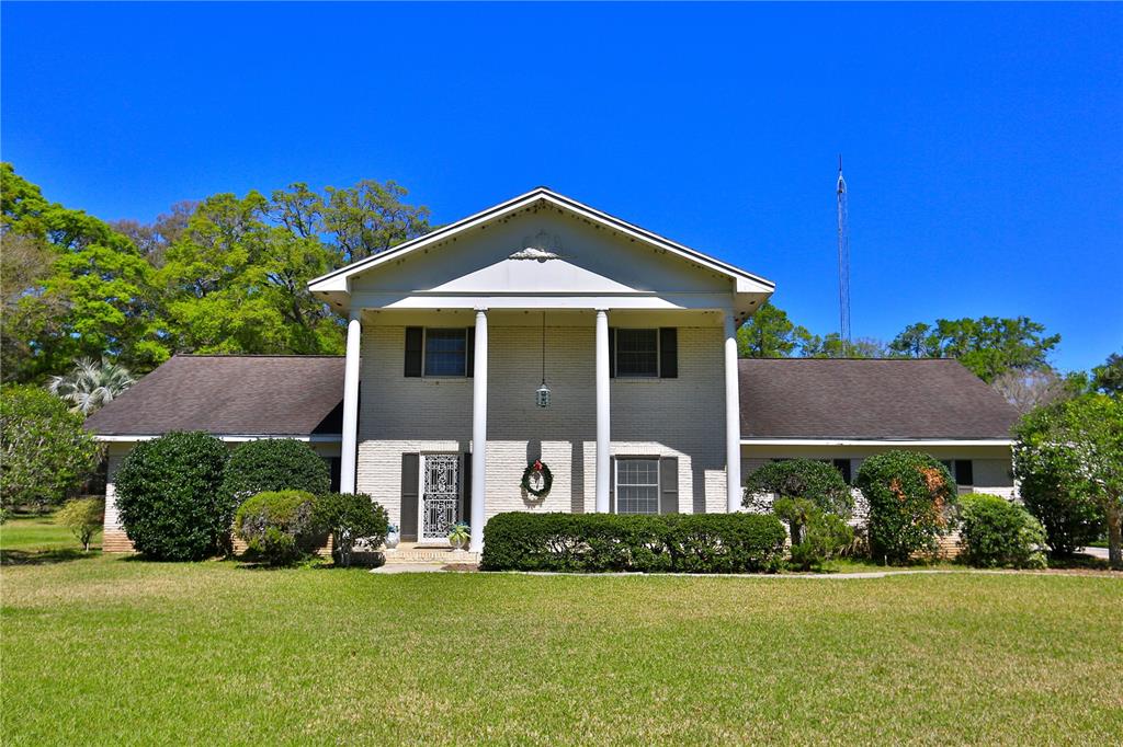A two-story house with a white brick facade, a front porch with columns, and a lawn — 2881 SE 41ST PLACE, OCALA, FL