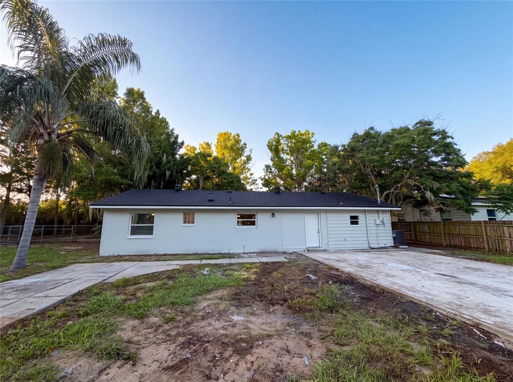 The exterior of a single-story house features a light-colored facade, a dark roof, and a driveway — 827 DORA AVENUE, TAVARES, FL