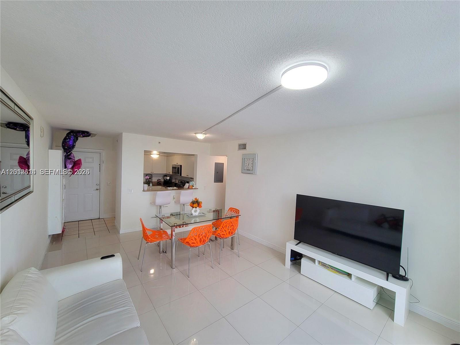 A bright, empty room features white tile floors, white walls, and a sliding glass door — 60 NW 37th Ave # 1208, Miami FL 33125, MIAMI, FL