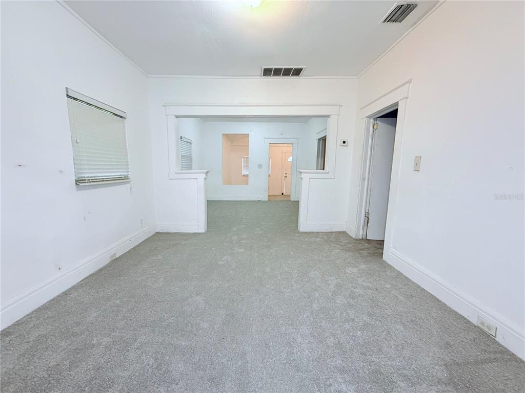 An empty room with gray carpet, white walls, and a wide opening to another space — 405 E DR. MARTIN LUTHER KING JR. BOULEVARD, TAMPA, FL