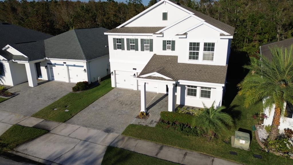 An aerial view of a two-story white house with a paved driveway and attached garage — 3059 BEAVER CREEK DRIVE, KISSIMMEE, FL