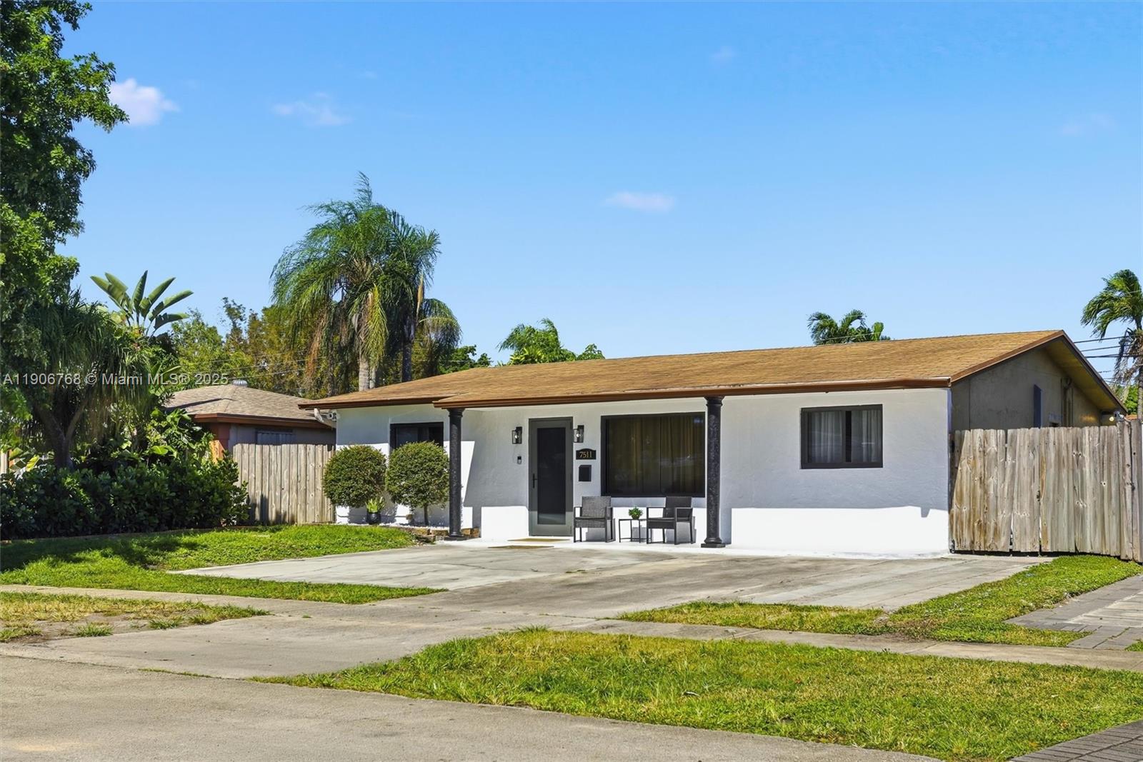 A single-story white house with a brown roof and a concrete driveway sits outdoors — 7511 Taylor St, Hollywood FL 33024, HOLLYWOOD, FL