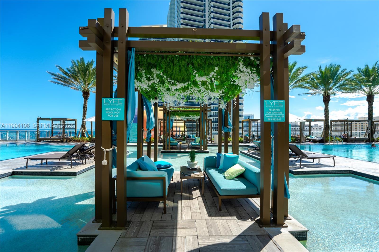 A poolside cabana features two blue sofas and a small table on a wooden deck — 4111 S Ocean Dr # 3008, Hollywood FL 33019, HOLLYWOOD, FL