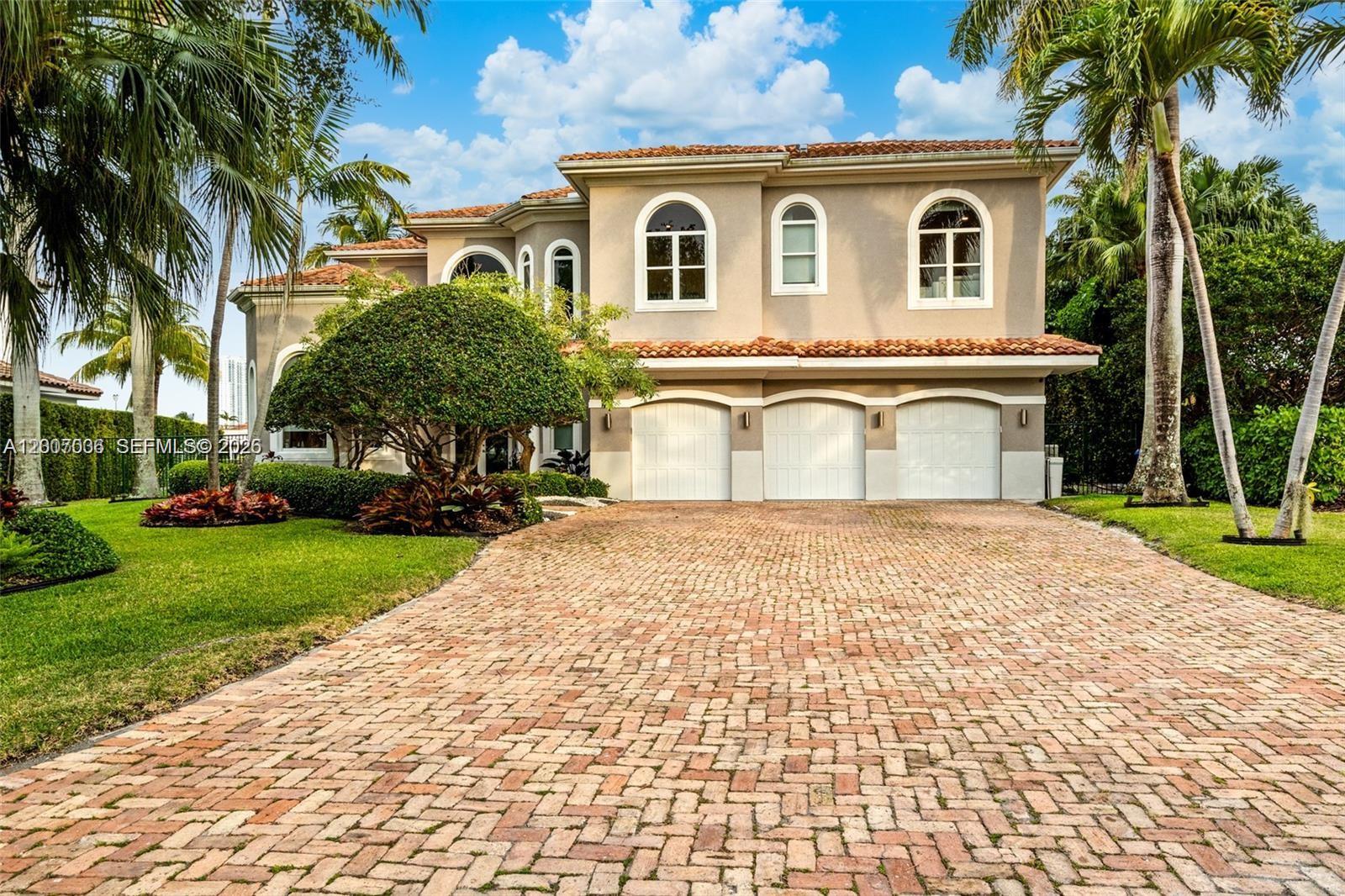 A two-story house with a brick driveway, three garage doors, and palm trees — 1260 Harbor Ct, Hollywood FL 33019, HOLLYWOOD, FL
