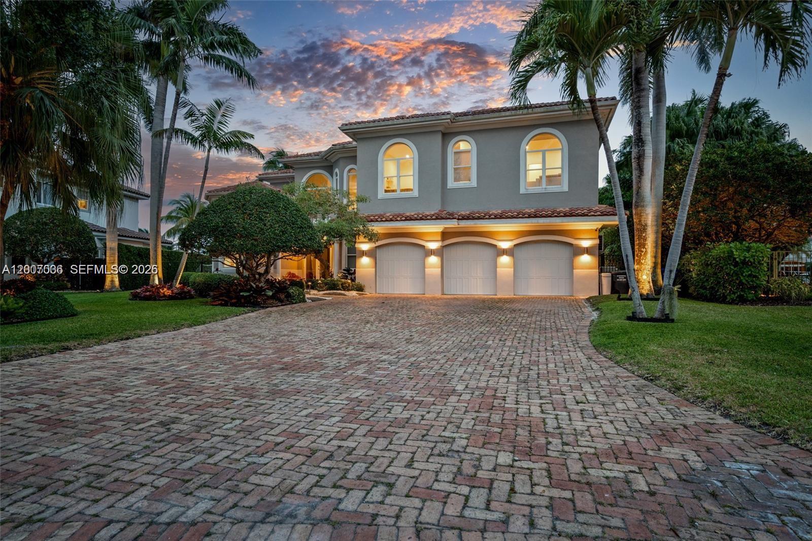 A two-story house with a three-car garage and a brick driveway at twilight — 1260 Harbor Ct, Hollywood FL 33019, HOLLYWOOD, FL
