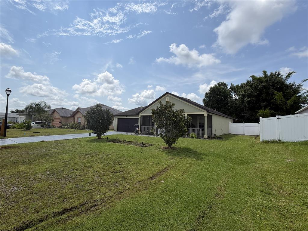 A single-story house with a garage and a screened porch sits on a grassy lot — 426 BAR COURT, POINCIANA, FL