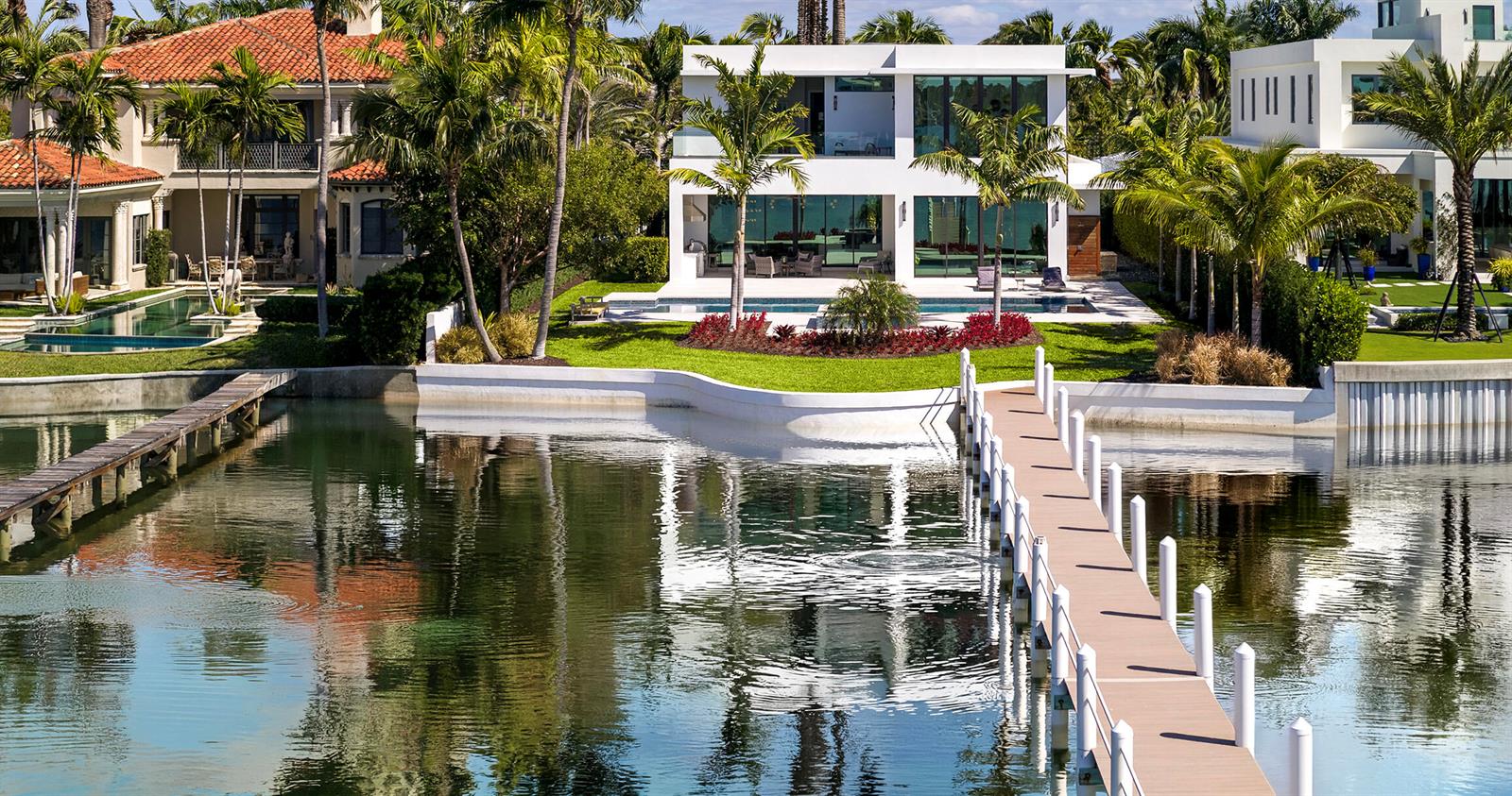 A modern white waterfront house with a dock and swimming pool on a sunny day — 807 N Atlantic Drive, Lantana FL 33462, LANTANA, FL