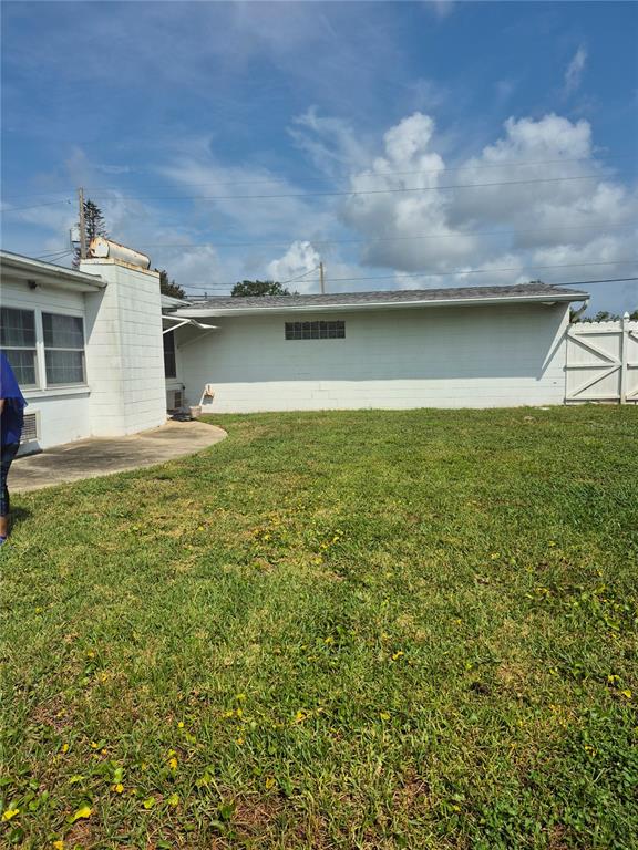 The exterior of a white concrete block house features a small glass block window — 2604 REEF COURT, ORLANDO, FL