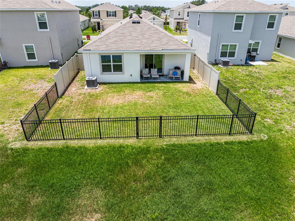 An aerial view shows a house with a fenced backyard and a covered patio — 3520 MAPLE GROVE WAY, PLANT CITY, FL