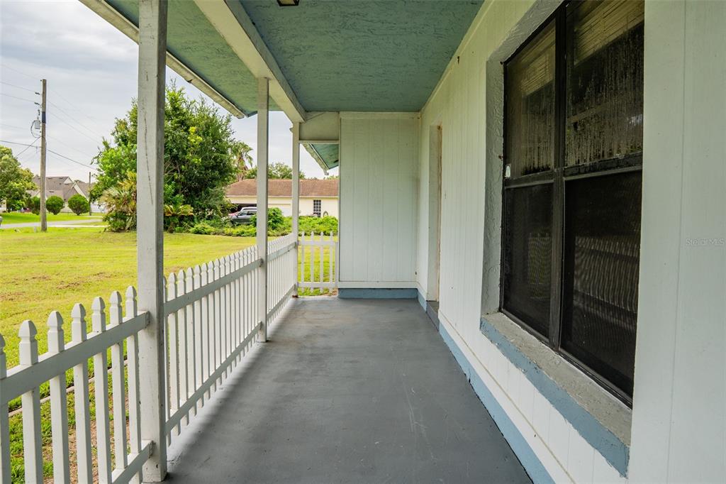 A covered porch with a white picket railing, gray floor, and light blue ceiling — 4148 BIG VALLEY BOULEVARD, KISSIMMEE, FL
