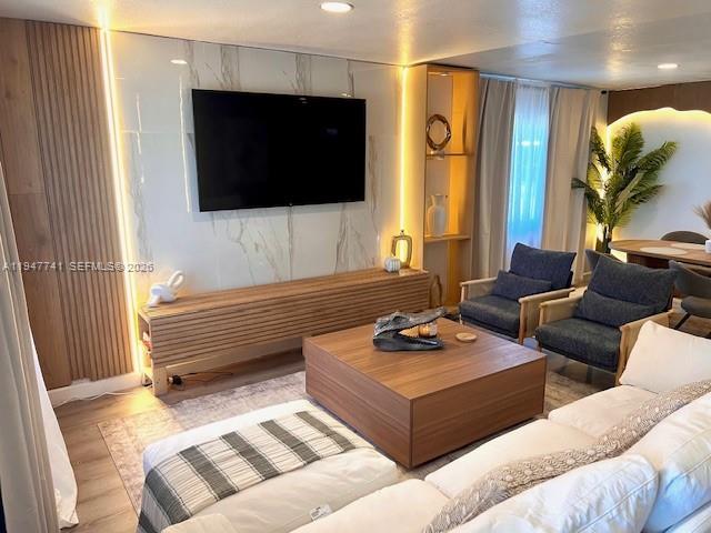 A modern living room features a marble accent wall, wood slat paneling, and a coffee table — 601 NW 10th St, Hallandale Beach FL 33009, HALLANDALE BEACH, FL