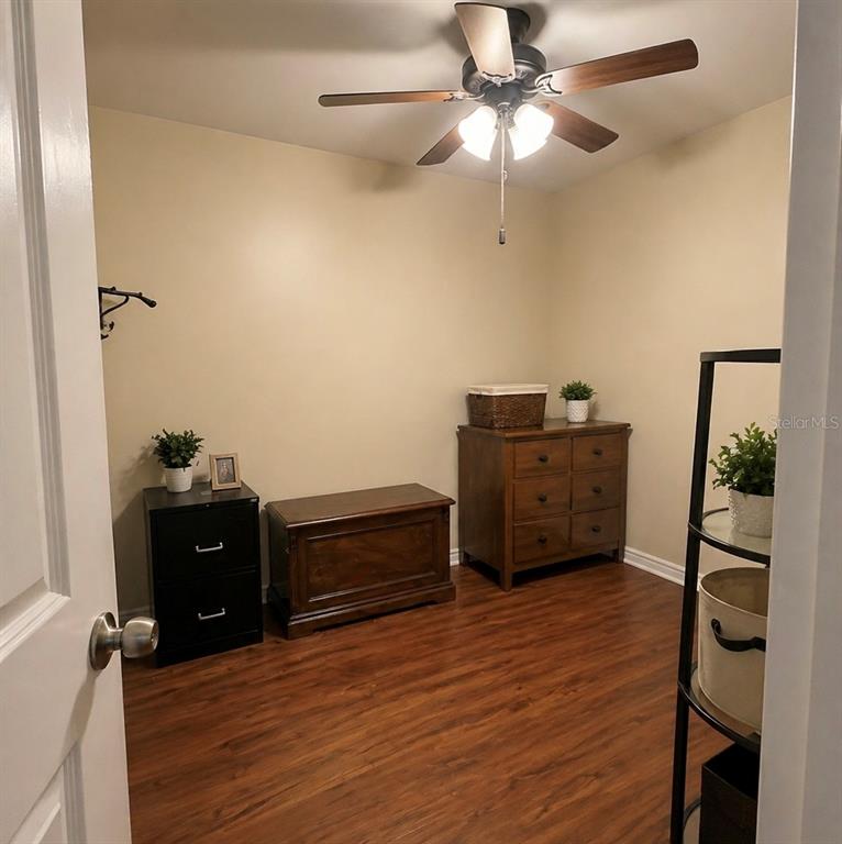 A bedroom features a bed, a dresser, a television stand, and a ceiling fan — 8604 N BRANCH AVENUE, TAMPA, FL