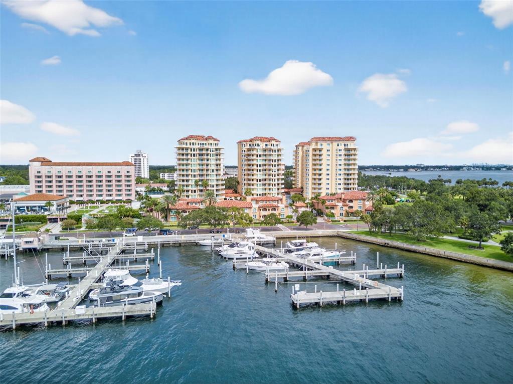 An aerial view shows a marina with docked boats in front of several large apartment buildings — 555 5TH AVENUE NE UNIT 521, ST PETERSBURG, FL