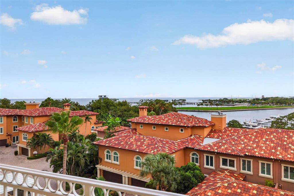An elevated view of Mediterranean-style buildings with red tile roofs overlooking a waterfront marina — 555 5TH AVENUE NE UNIT 521, ST PETERSBURG, FL
