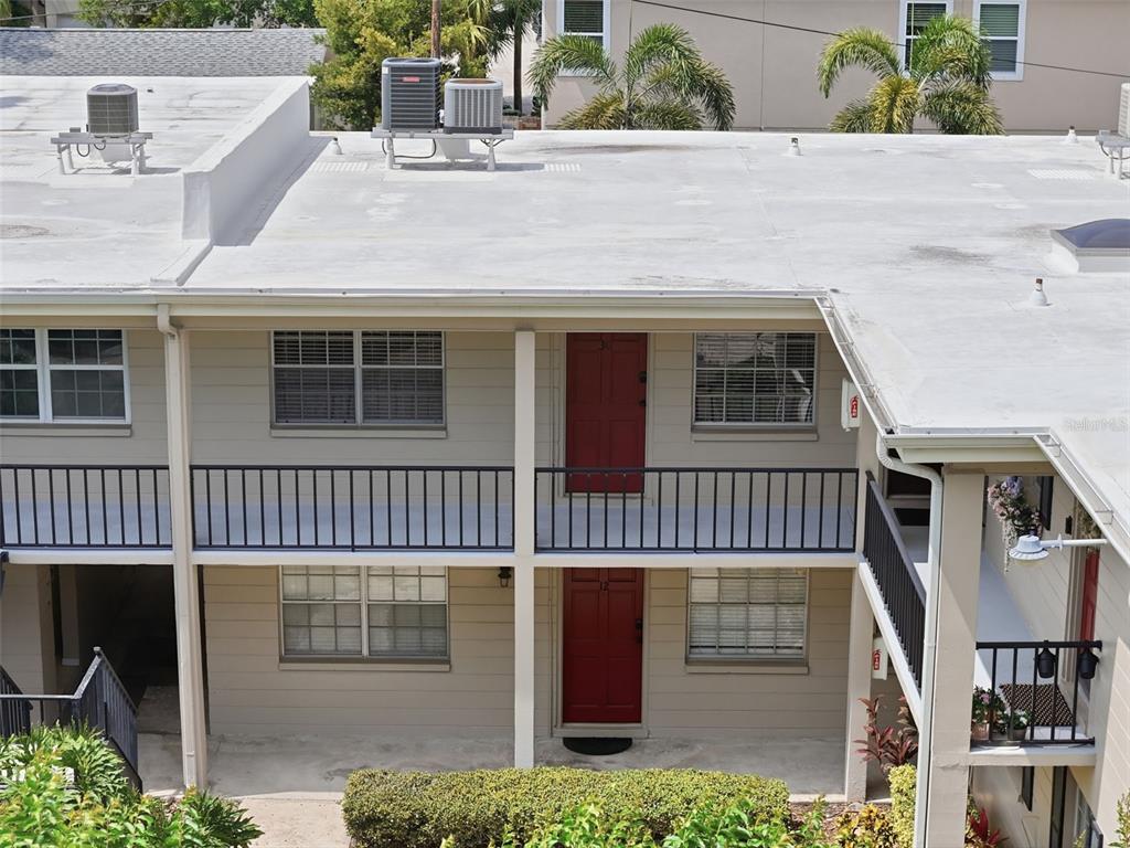 A two-story apartment building exterior with a grassy lawn and trees at sunset — 2207 S CAROLINA AVENUE UNIT 30, TAMPA, FL