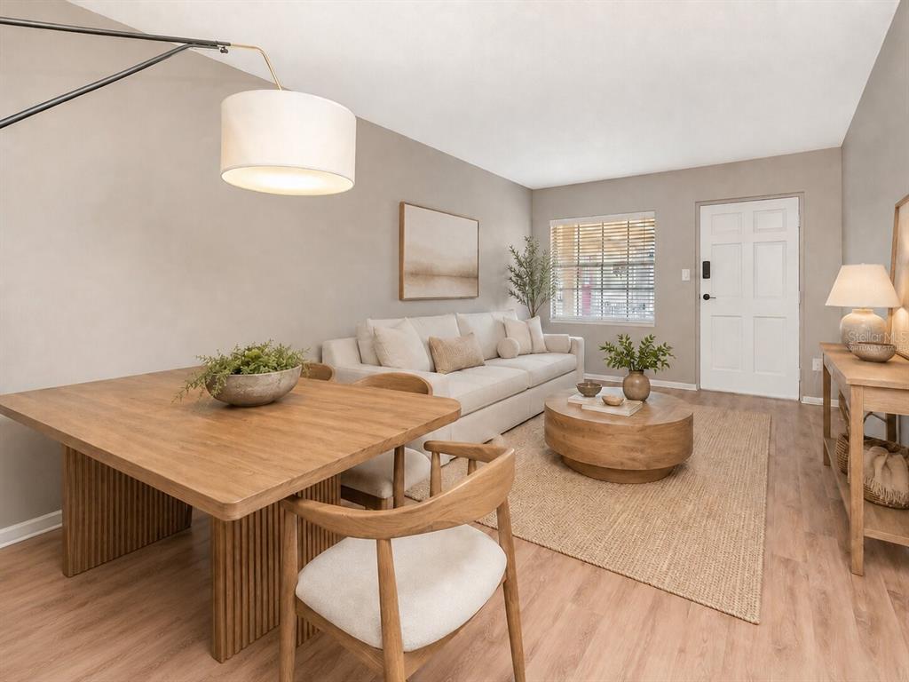 A living and dining area features light wood flooring, neutral walls, and modern wooden furniture — 2207 S CAROLINA AVENUE UNIT 30, TAMPA, FL