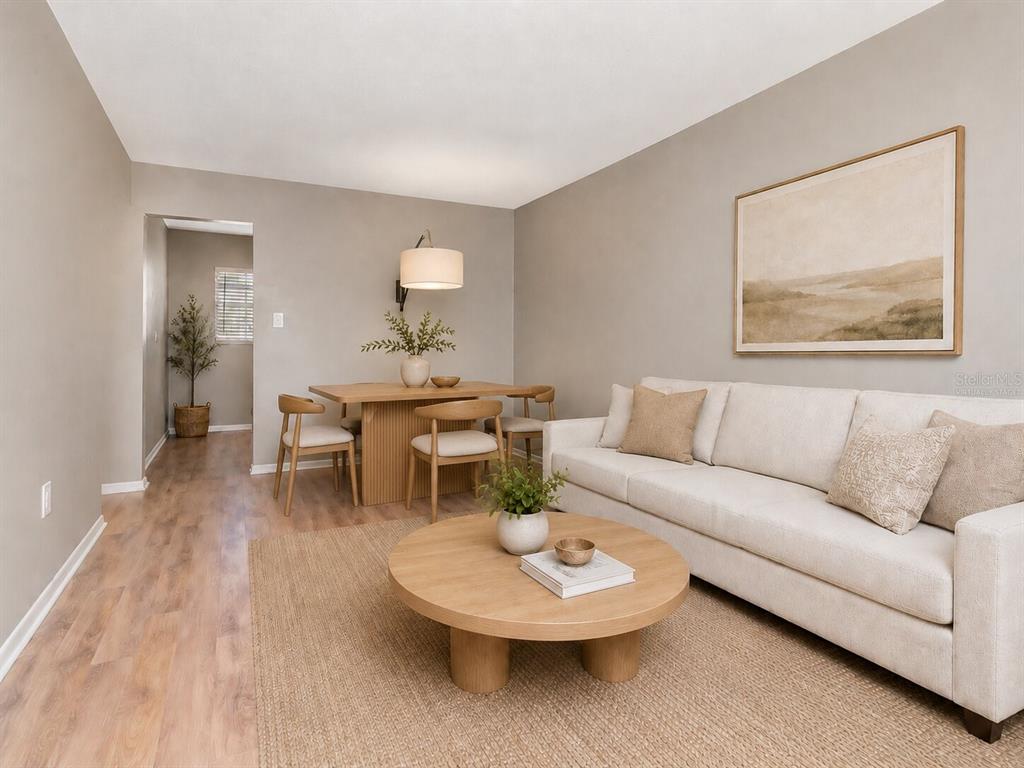 A living and dining room featuring light wood flooring, a beige sofa, and round table — 2207 S CAROLINA AVENUE UNIT 30, TAMPA, FL