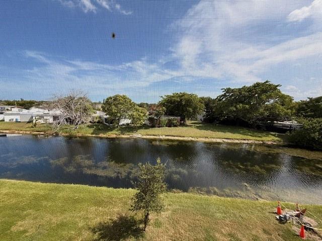 A view of a canal and grassy yard from behind a window screen — 9660 Sunrise Lakes Boulevard # 306, Sunrise FL 33322, SUNRISE, FL