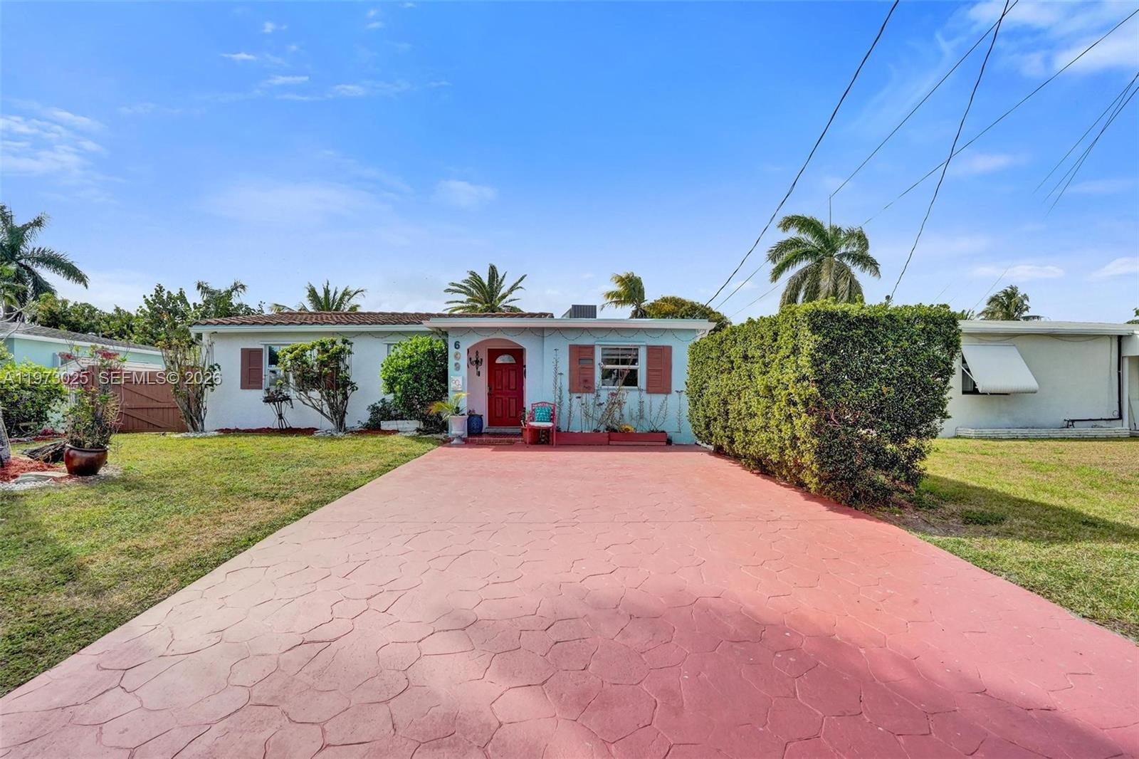 A single-story house with a red driveway, a red front door, and a tall hedge — 609 SW 2nd Ave, Hallandale Beach FL 33009, HALLANDALE BEACH, FL