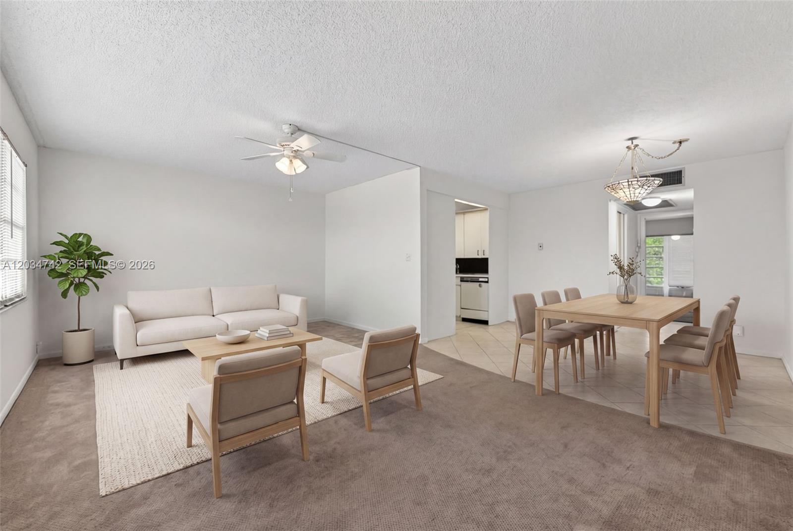 A living and dining area features neutral furniture, carpeted and tiled floors, and a ceiling fan — 2401 Antigua Cir # E3, Coconut Creek FL 33066, COCONUT CREEK, FL