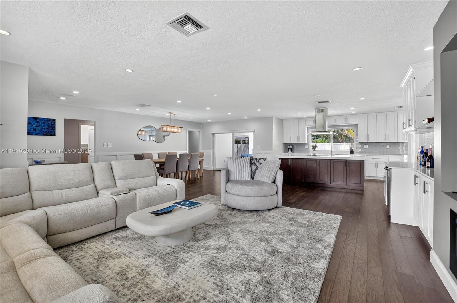 An open-concept living room features a sectional sofa, dining area, and a modern kitchen — 5660 Golfway Dr # 0, Boca Raton FL 33433, BOCA RATON, FL