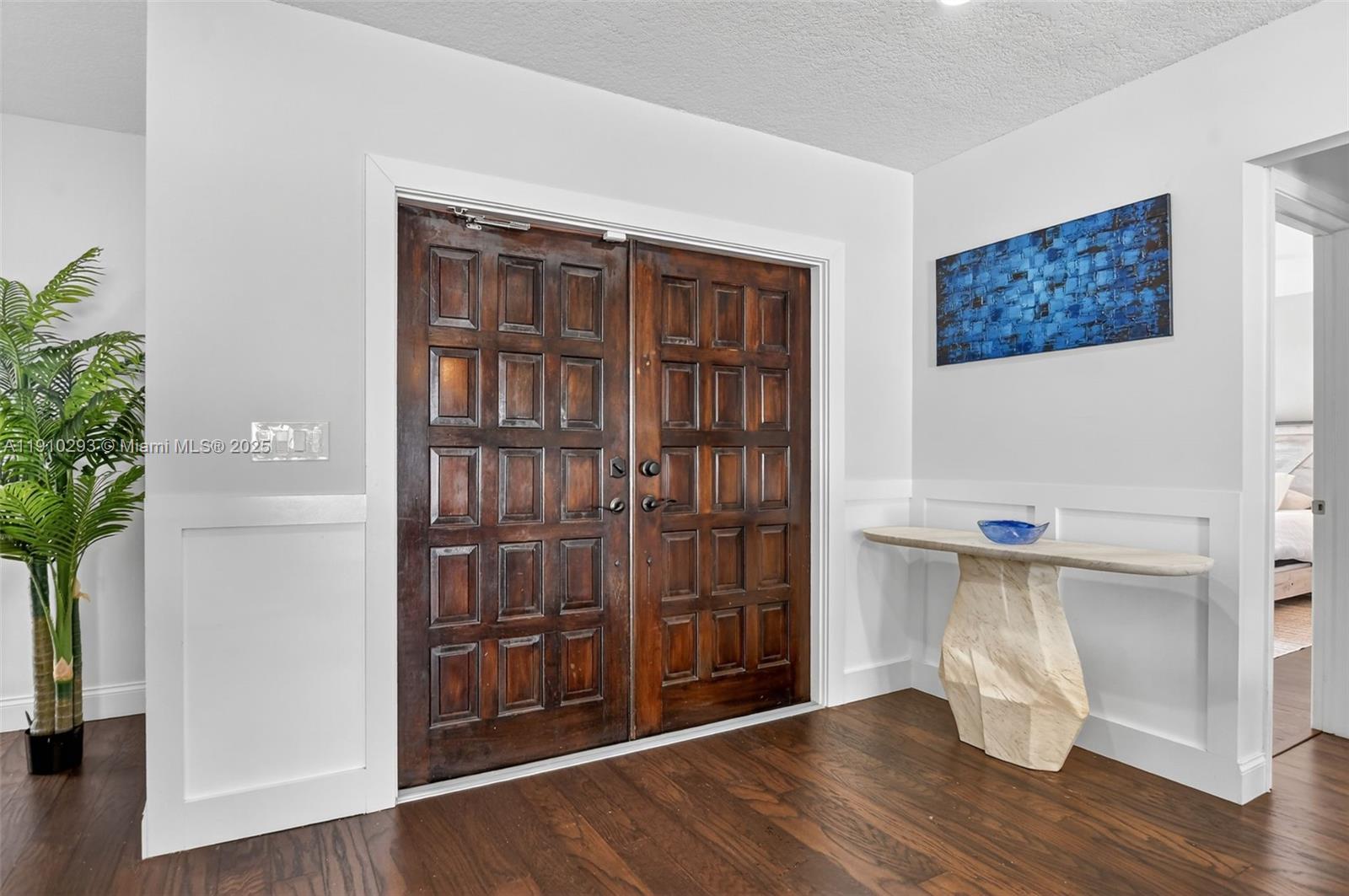 An entryway features double wooden doors, a stone console table, and a blue wall painting — 5660 Golfway Dr # 0, Boca Raton FL 33433, BOCA RATON, FL