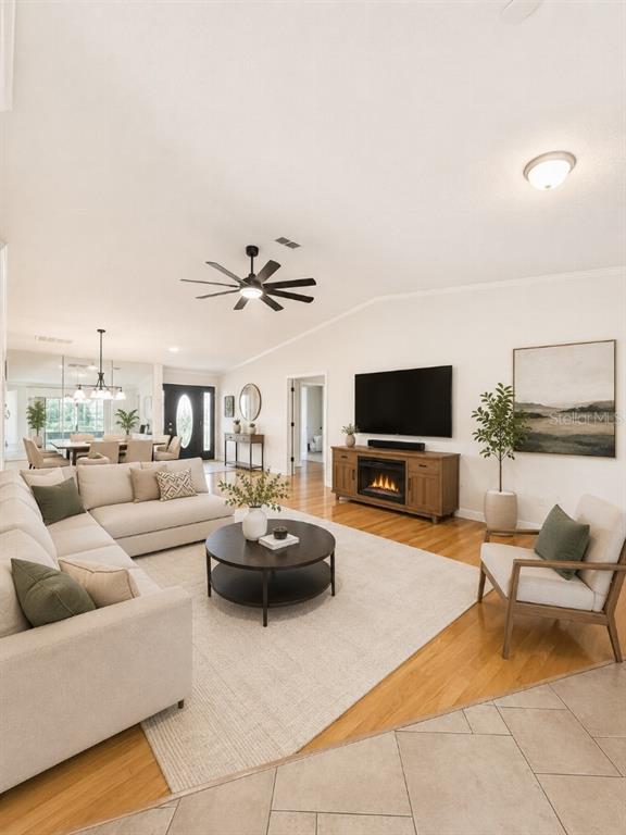 A living room features a sectional sofa, a fireplace console, and hardwood flooring — 3104 SAND TRAP COURT, LAKELAND, FL