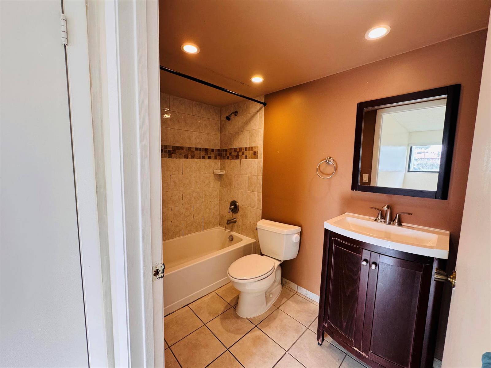 A bathroom features a tub-shower combination, a toilet, and a dark wood vanity — 20681 NE 4th Place # 105, Miami FL 33179, MIAMI, FL