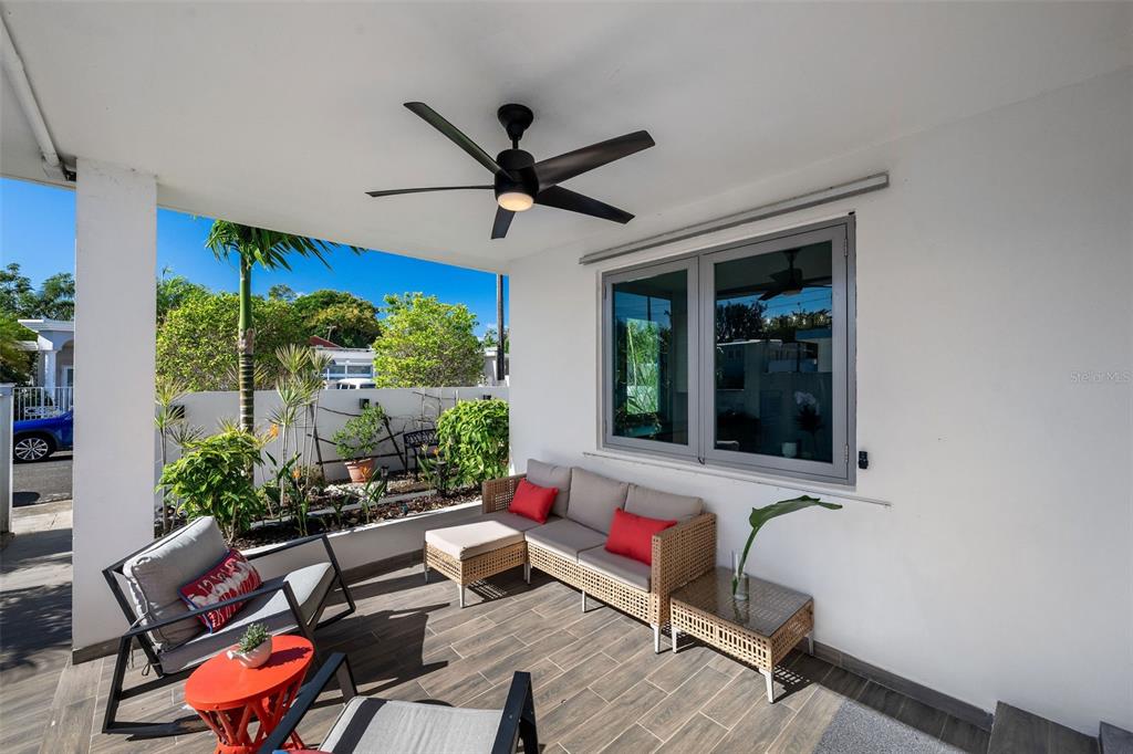 A covered patio features wicker furniture, a ceiling fan, and a view of the yard — 4 MAR DEL JAPON, CAROLINA, PR