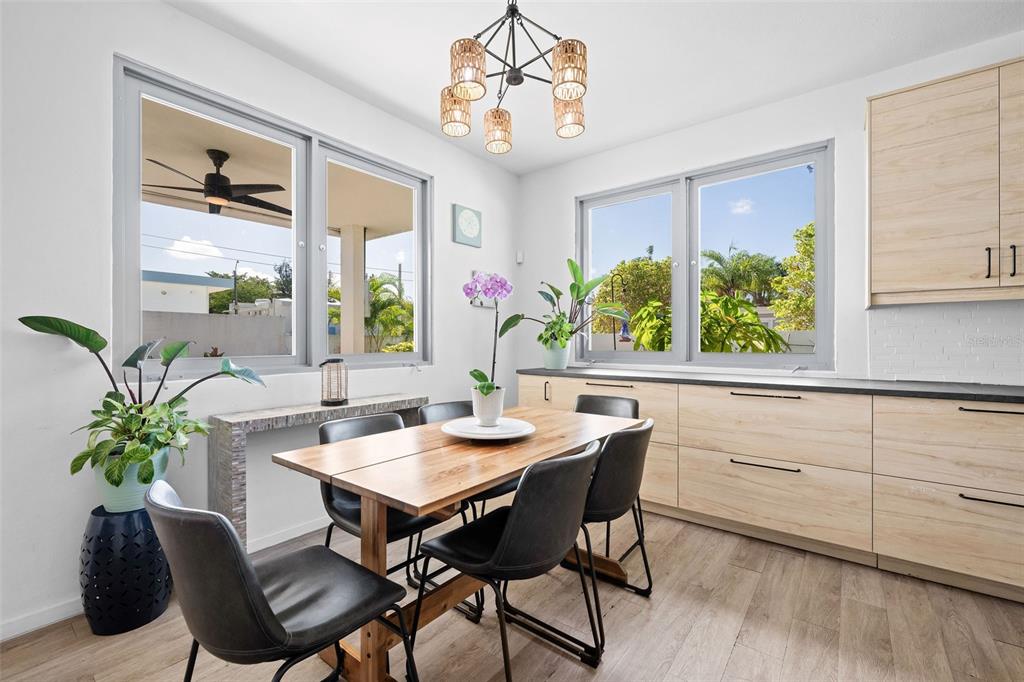 A dining area features a wooden table, black chairs, light wood cabinetry, and large windows — 4 MAR DEL JAPON, CAROLINA, PR
