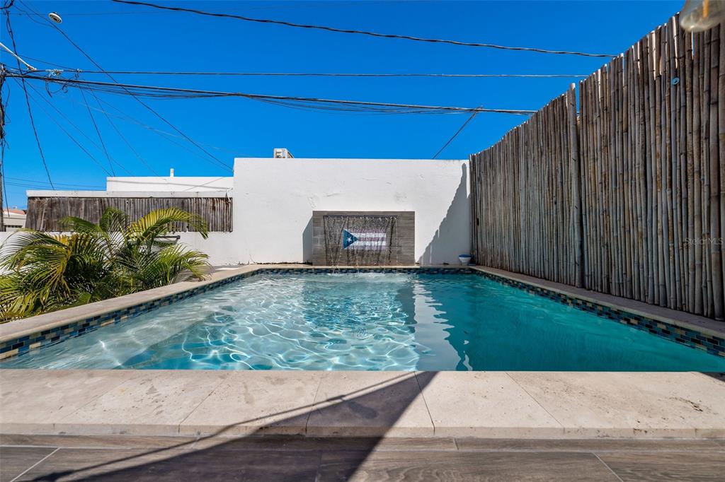 A rectangular swimming pool features a water feature with a Puerto Rican flag design — 4 MAR DEL JAPON, CAROLINA, PR