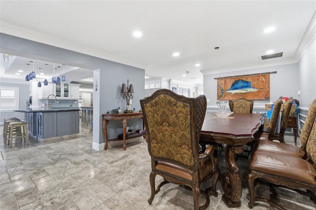 A dining room with a large wooden table and ornate chairs adjacent to a kitchen — 3874 48TH AVENUE S, ST PETERSBURG, FL