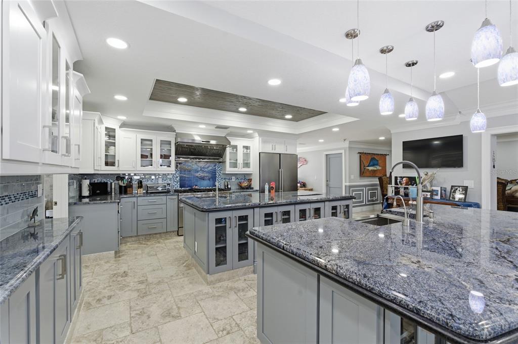 A spacious kitchen features gray cabinets, blue granite countertops, a large island, and pendant lighting — 3874 48TH AVENUE S, ST PETERSBURG, FL