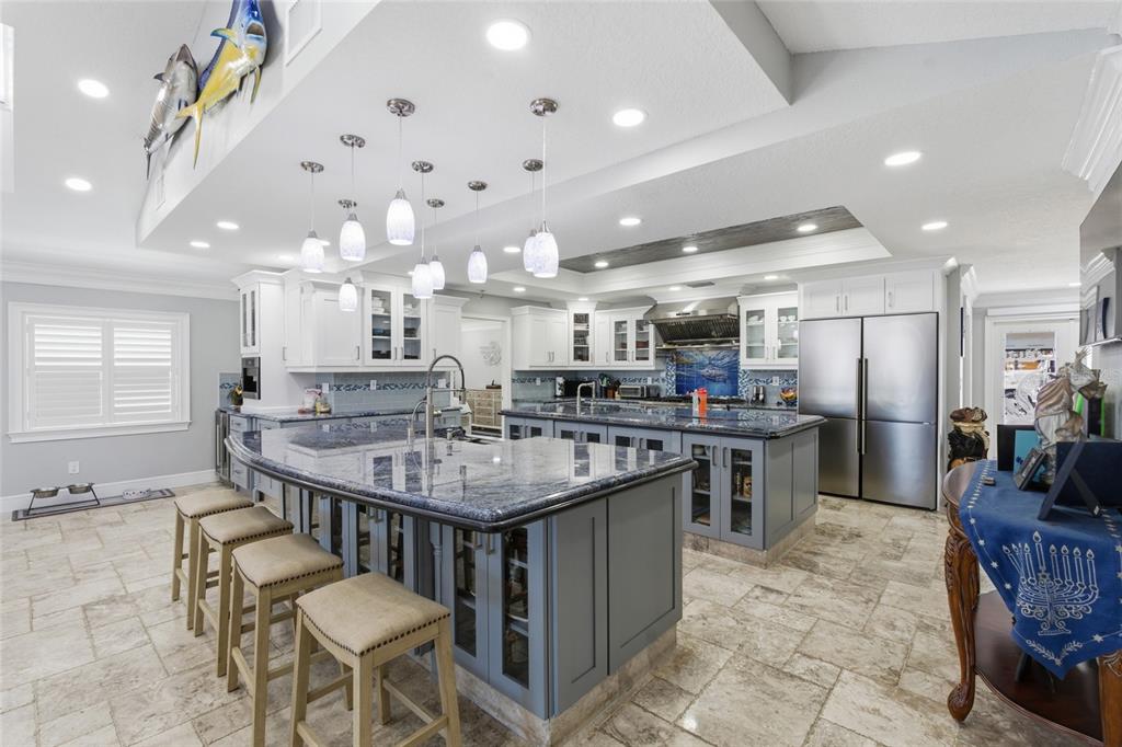 A spacious kitchen features two large islands with blue granite countertops and grey cabinetry — 3874 48TH AVENUE S, ST PETERSBURG, FL