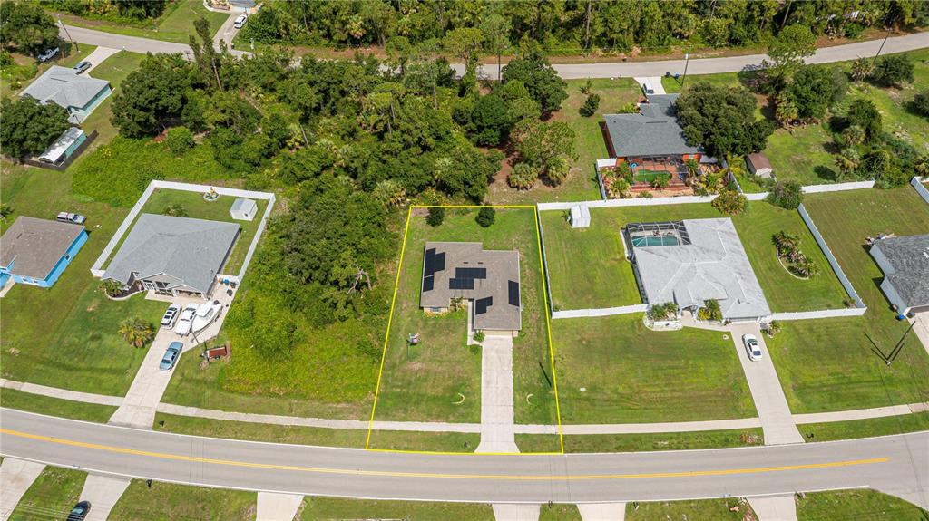 An aerial view shows a single-story house with solar panels on a suburban residential lot — 2555 ATWATER DRIVE, NORTH PORT, FL