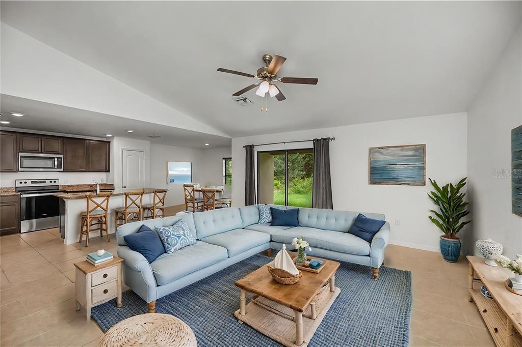 A light blue sectional sofa sits on a blue rug in a living room — 2555 ATWATER DRIVE, NORTH PORT, FL