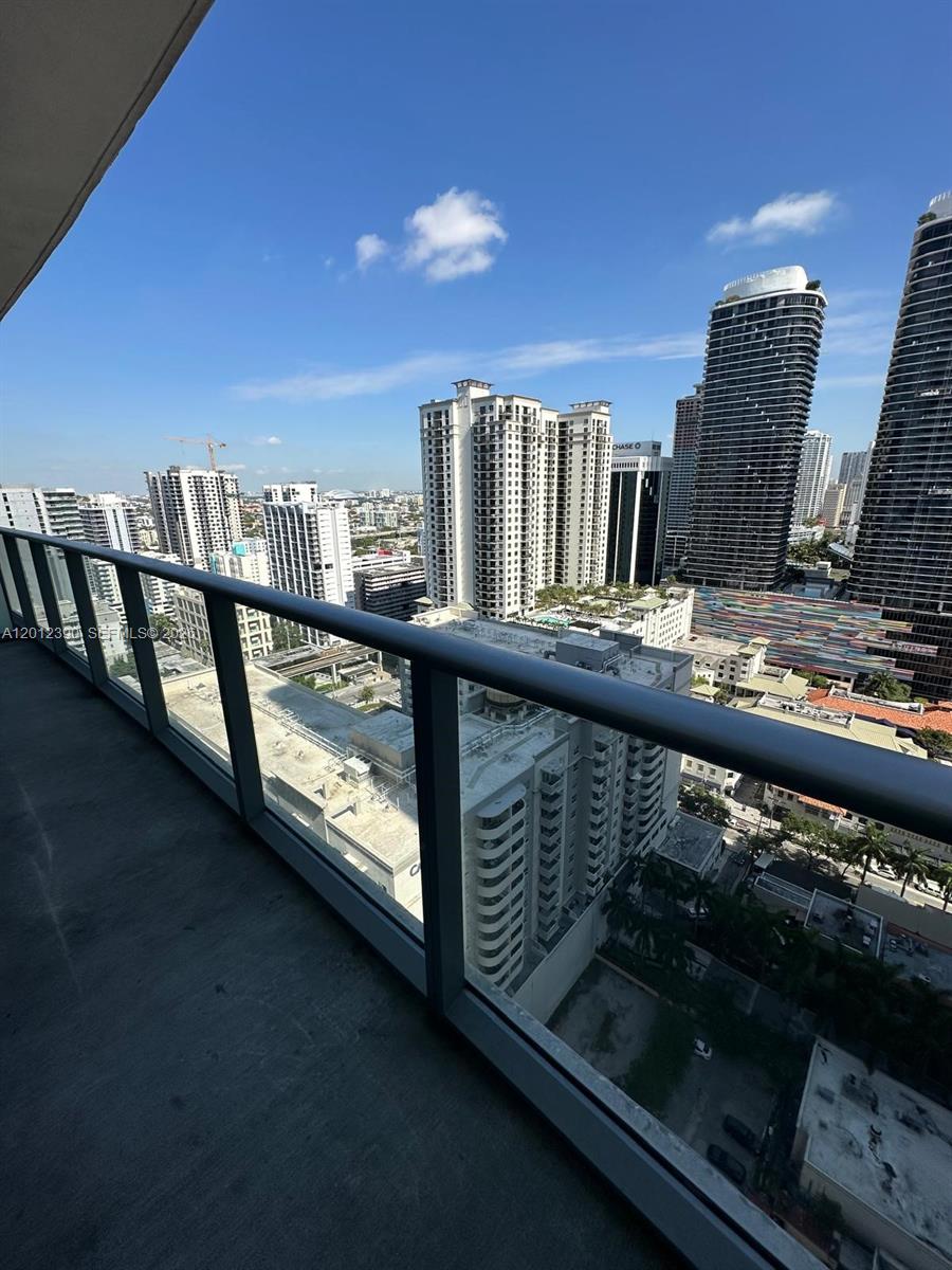 A high-rise balcony overlooks a dense urban cityscape with multiple skyscrapers under a blue sky — 1100 S Miami Ave # 2608, Miami FL 33130, MIAMI, FL