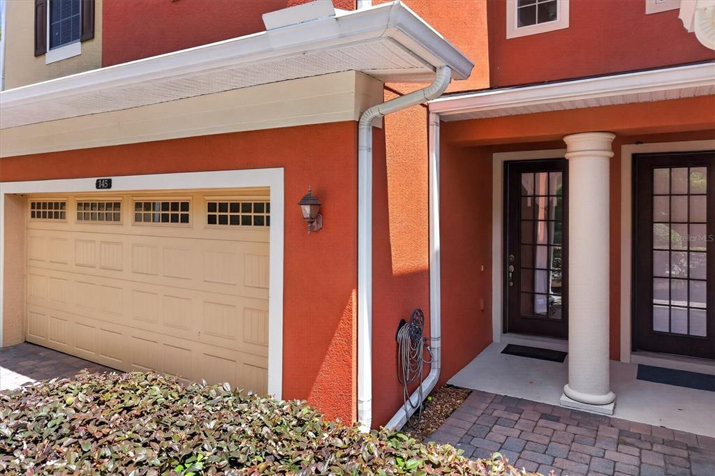 A tan garage door and a front entryway with a column are on a house — 145 STENHOUSE LANE, LONGWOOD, FL