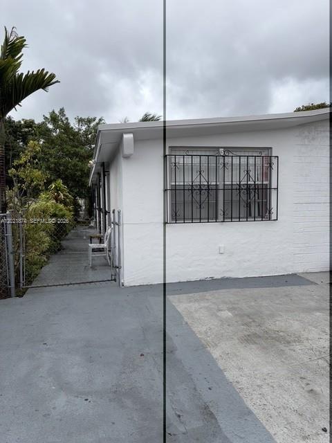 A white exterior wall features a window with black security bars and a side walkway — 336 E 41st St, Hialeah FL 33013, HIALEAH, FL
